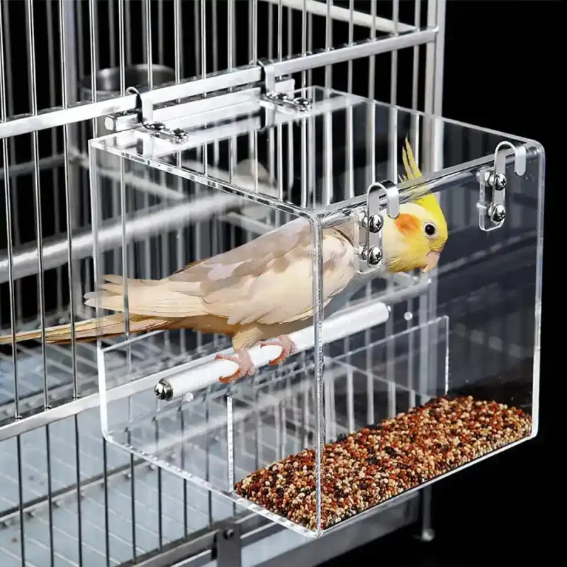 A no-mess bird cage feeder attached to a cage with a cockatiel eating inside